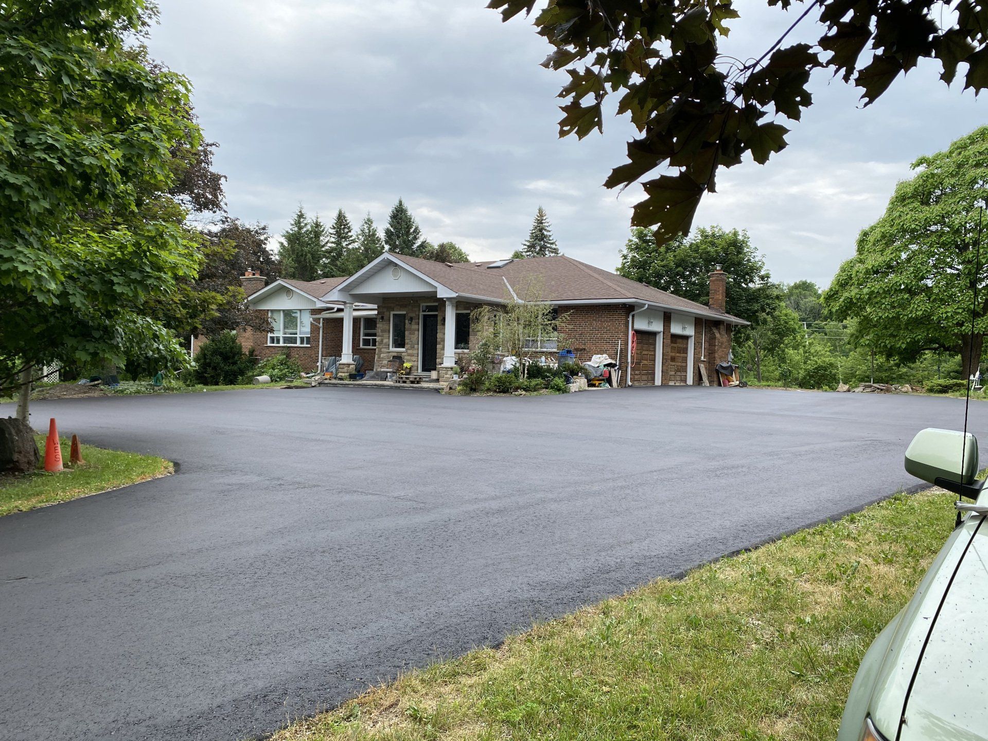 A car is parked in front of a large house