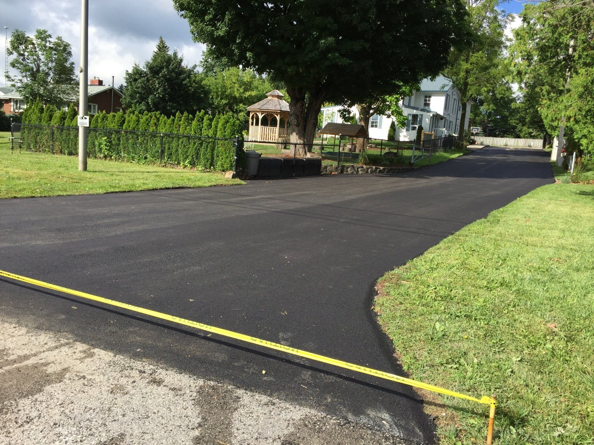 A yellow tape measure is laying on the side of a road.