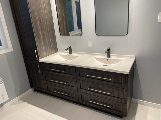 Une salle de bain avec deux lavabos et deux miroirs.