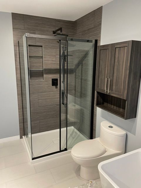 Une salle de bain avec WC, lavabo et cabine de douche.