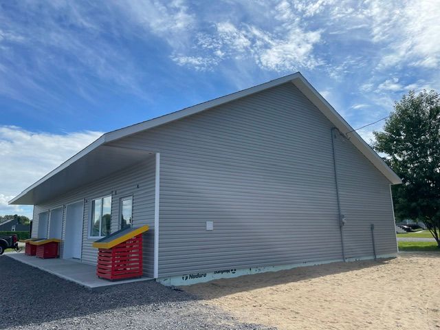 Une petite maison avec un ciel bleu et des nuages ​​en arrière-plan.
