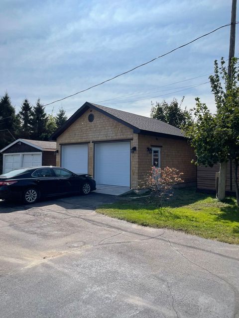 Une voiture noire est garée devant un garage