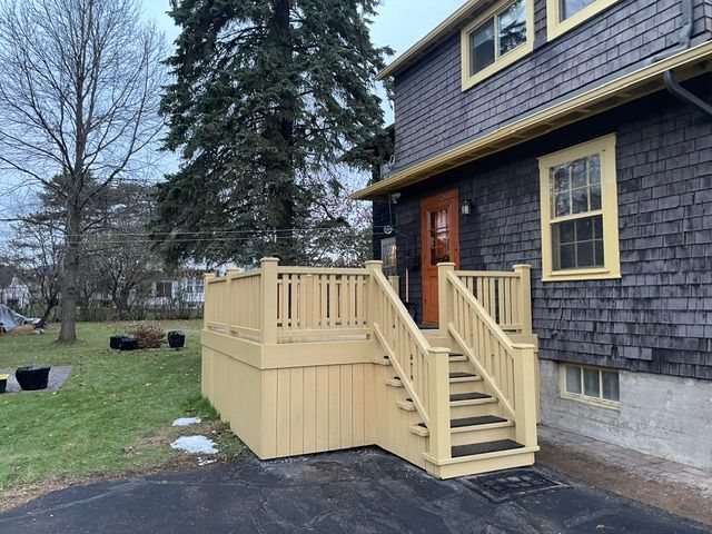 Une maison avec une terrasse et des escaliers devant