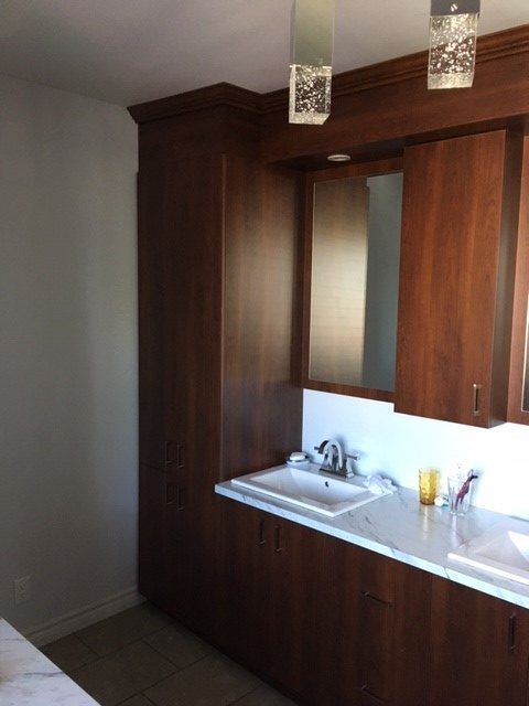 Une salle de bain avec des armoires en bois et un lavabo