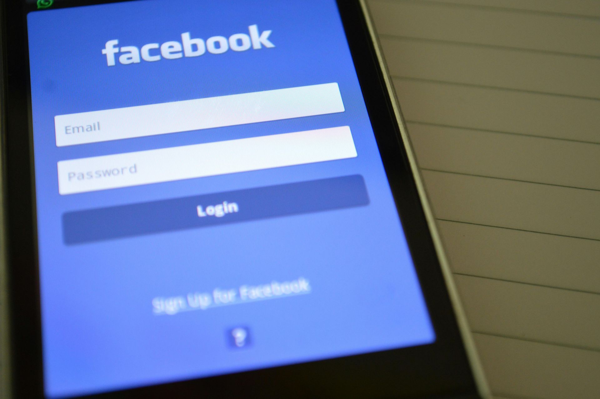 Facebook login screen on a smartphone, email and password fields displayed.