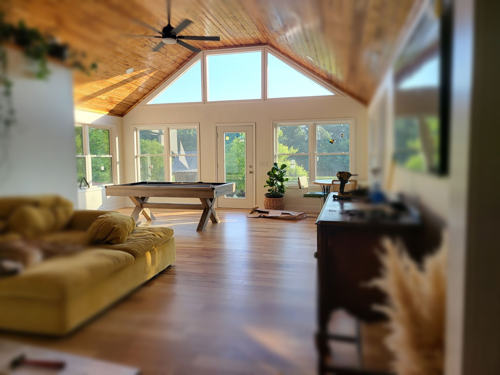 A room with a table and stools and a potted plant