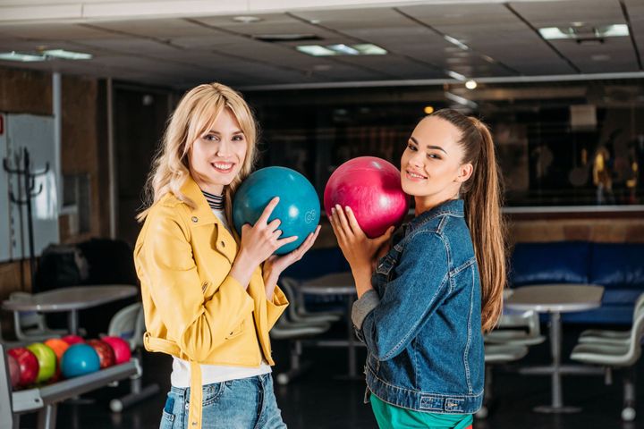 Two Women Holding Bowling Balls in a Bowling Alley - Vandalia, MO – Baum's Family Fun Center