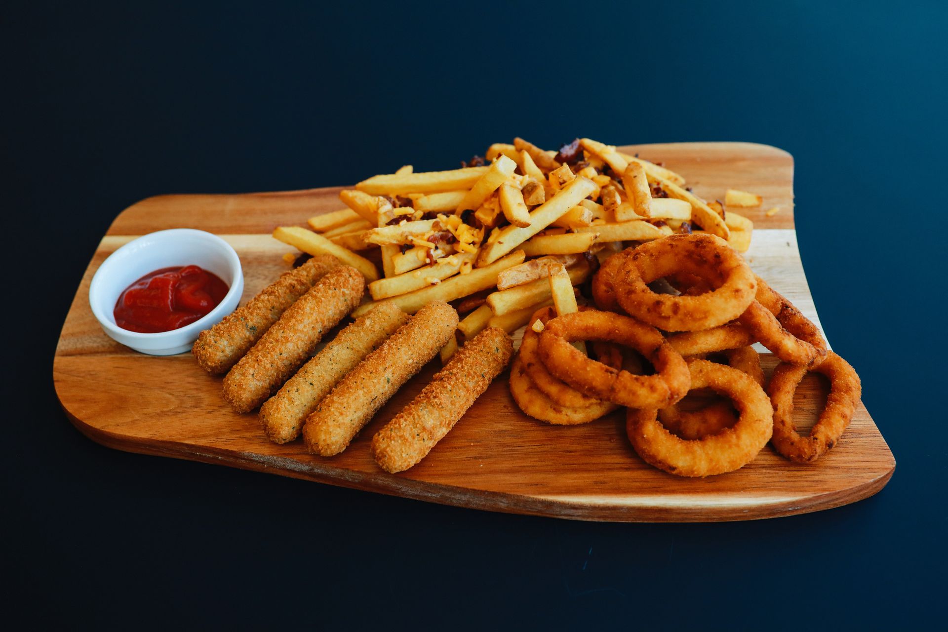 Wooden Cutting Board with Fries, Mozzarella Sticks, Onion Rings, and Ketchup – Vandalia, MO – Baum's Family Fun Center