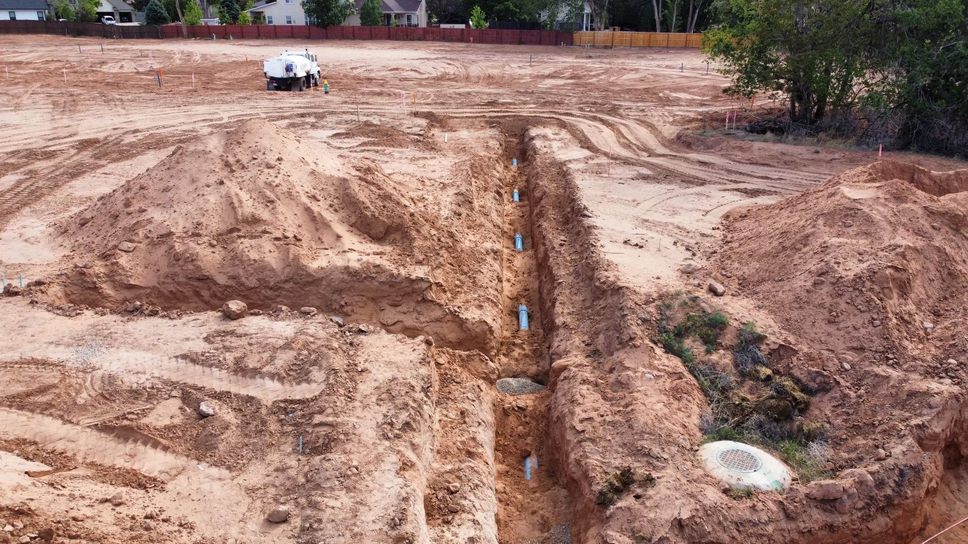 A white truck is parked in the middle of a dirt field.