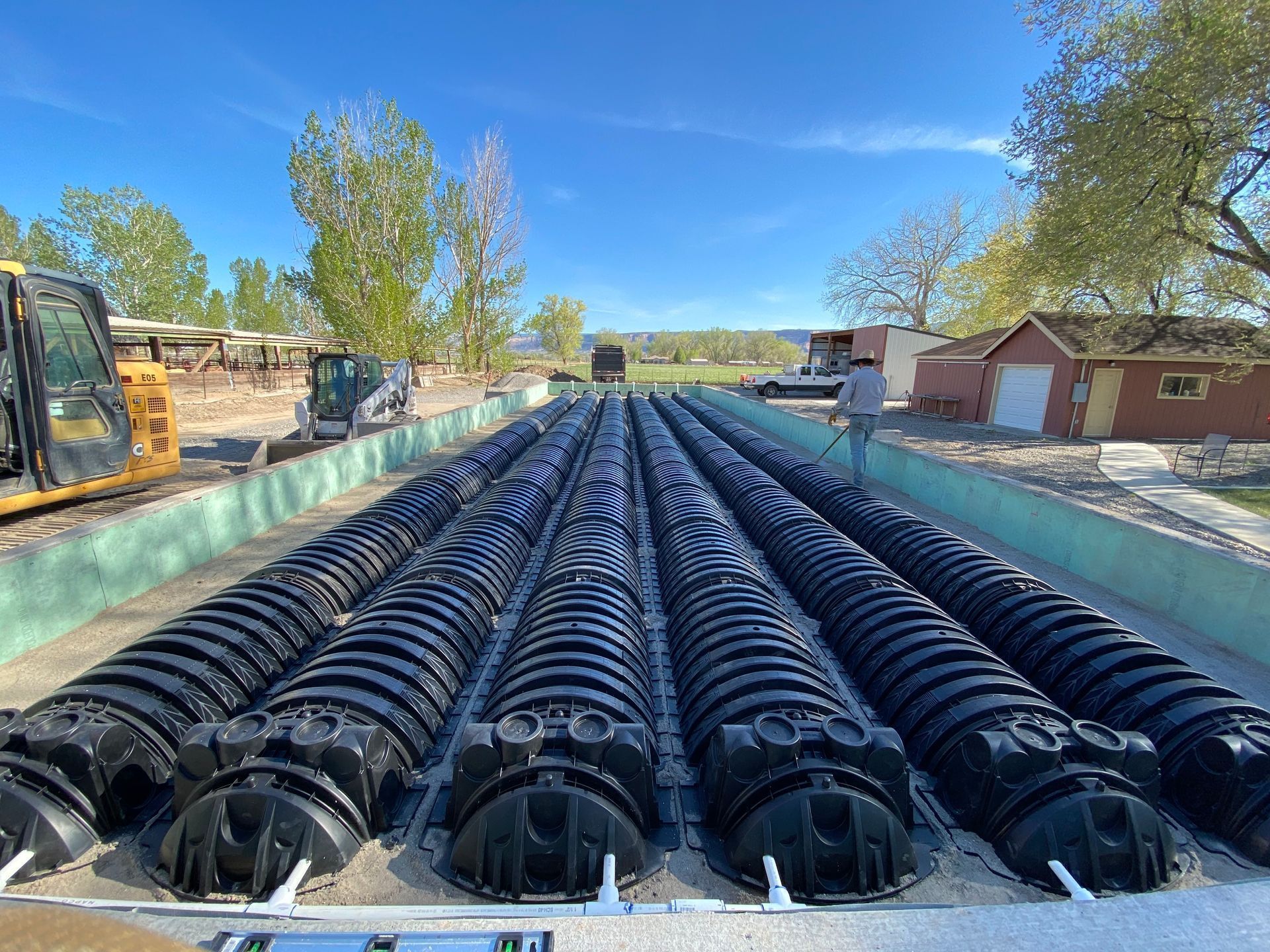 A row of black pipes are sitting on top of a concrete surface.