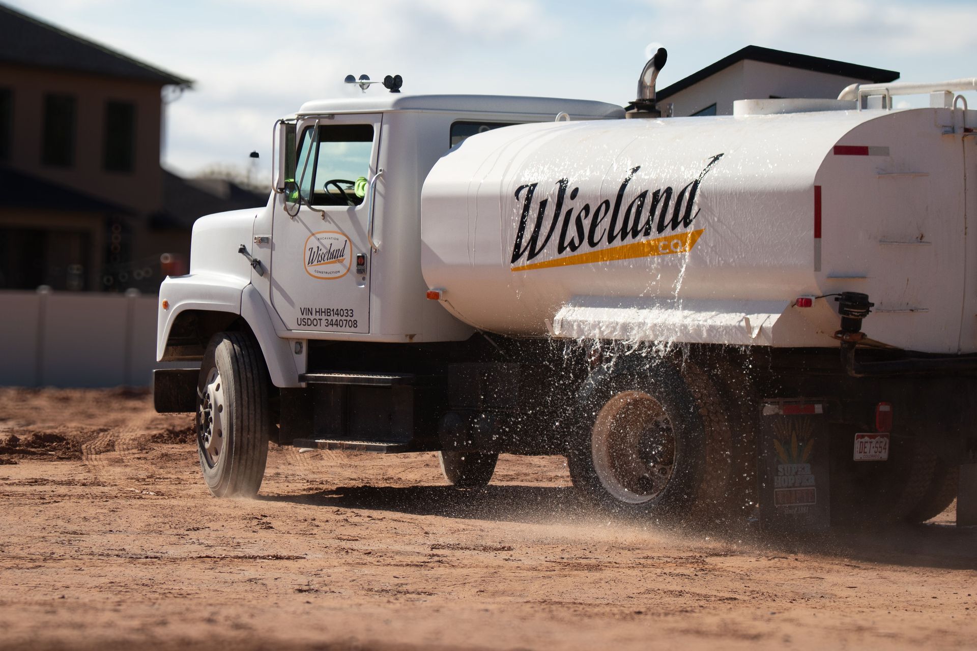 A yellow excavator is digging a hole in the ground.