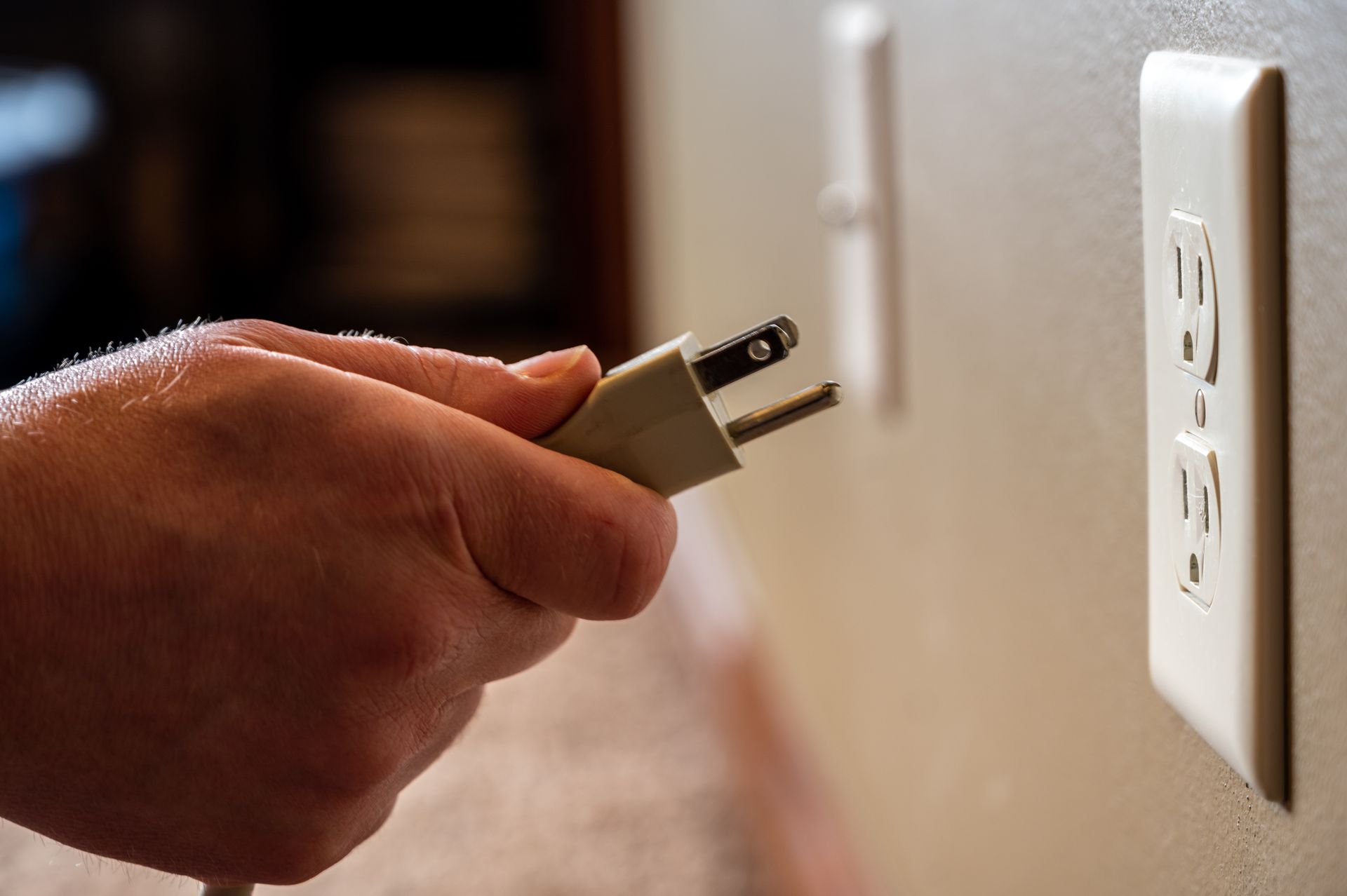 a person is plugging a plug into a wall outlet