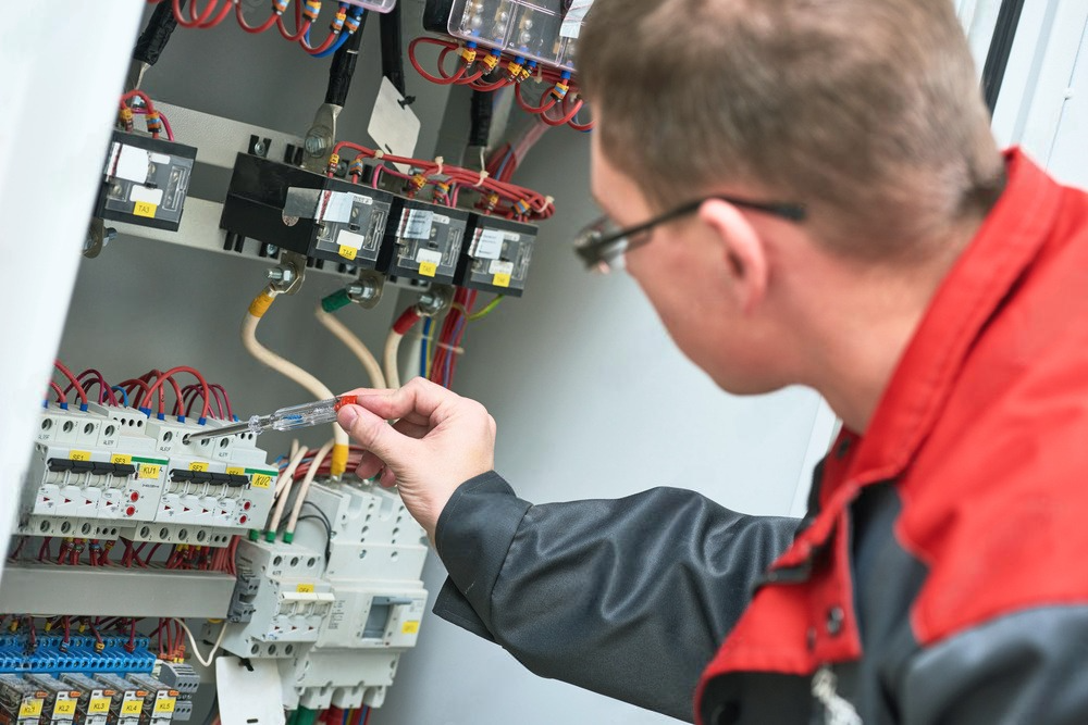 a man in a red jacket is working on a circuit board