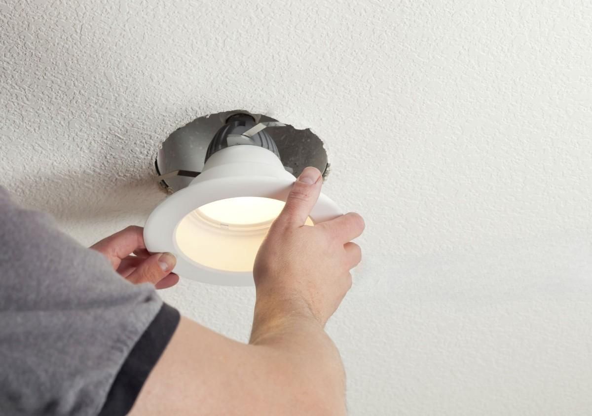 a person is installing a light in the ceiling