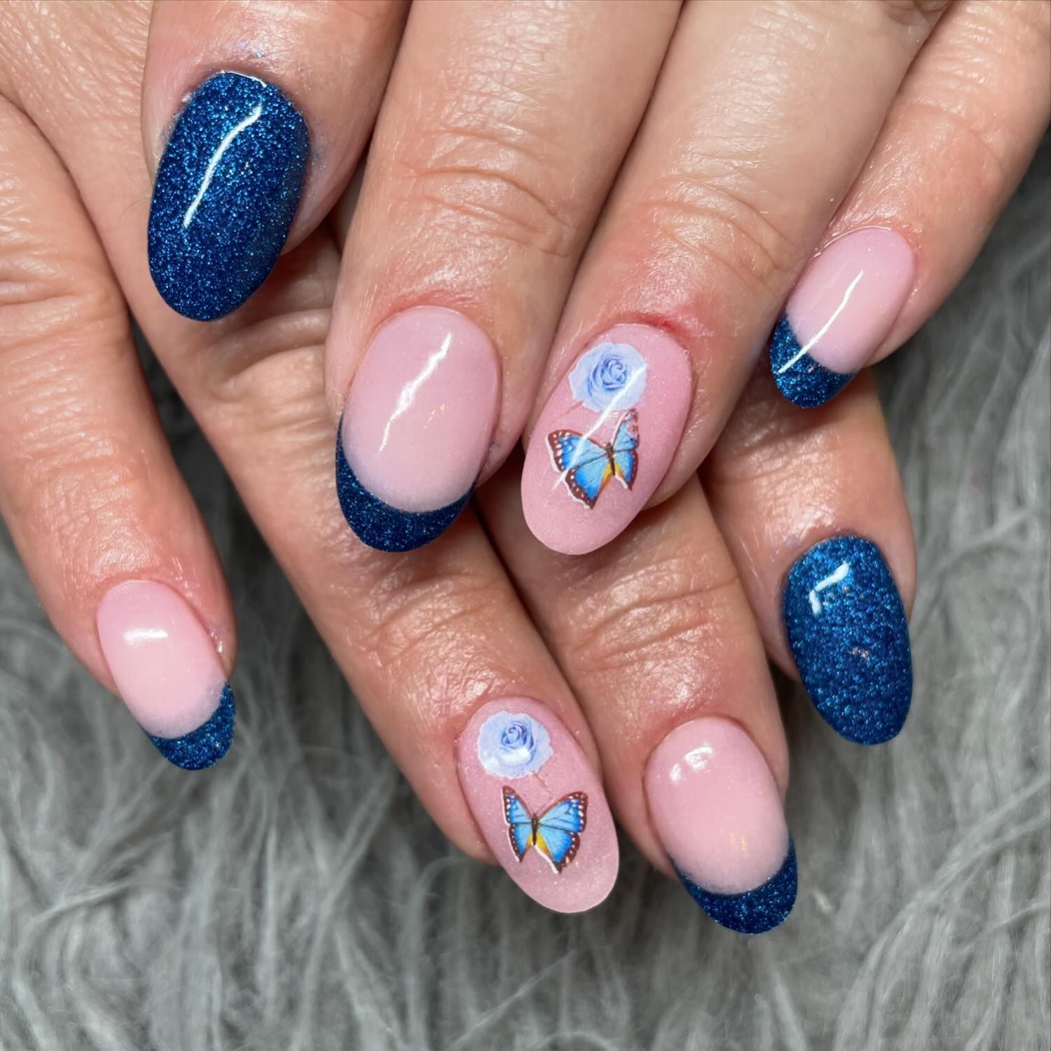 A close up of a woman 's nails with butterflies on them