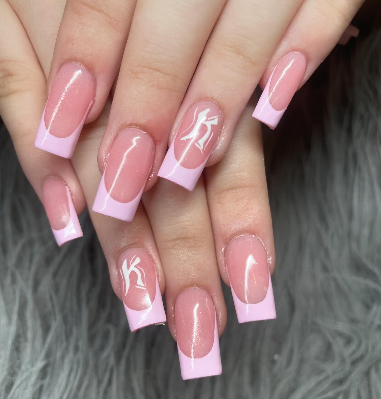 A close up of a woman 's nails with a pink french manicure