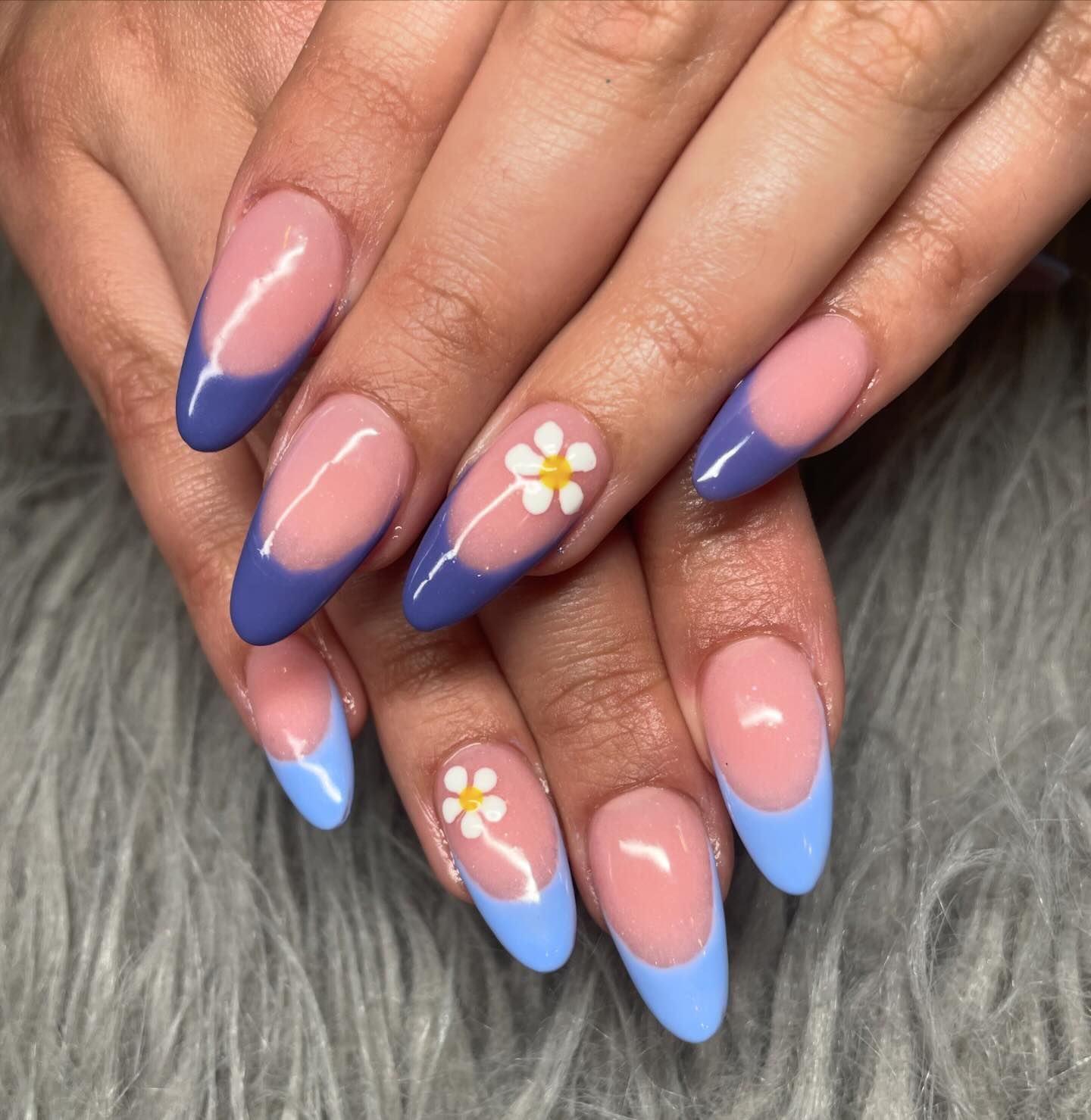 A close up of a woman 's nails with a flower on them