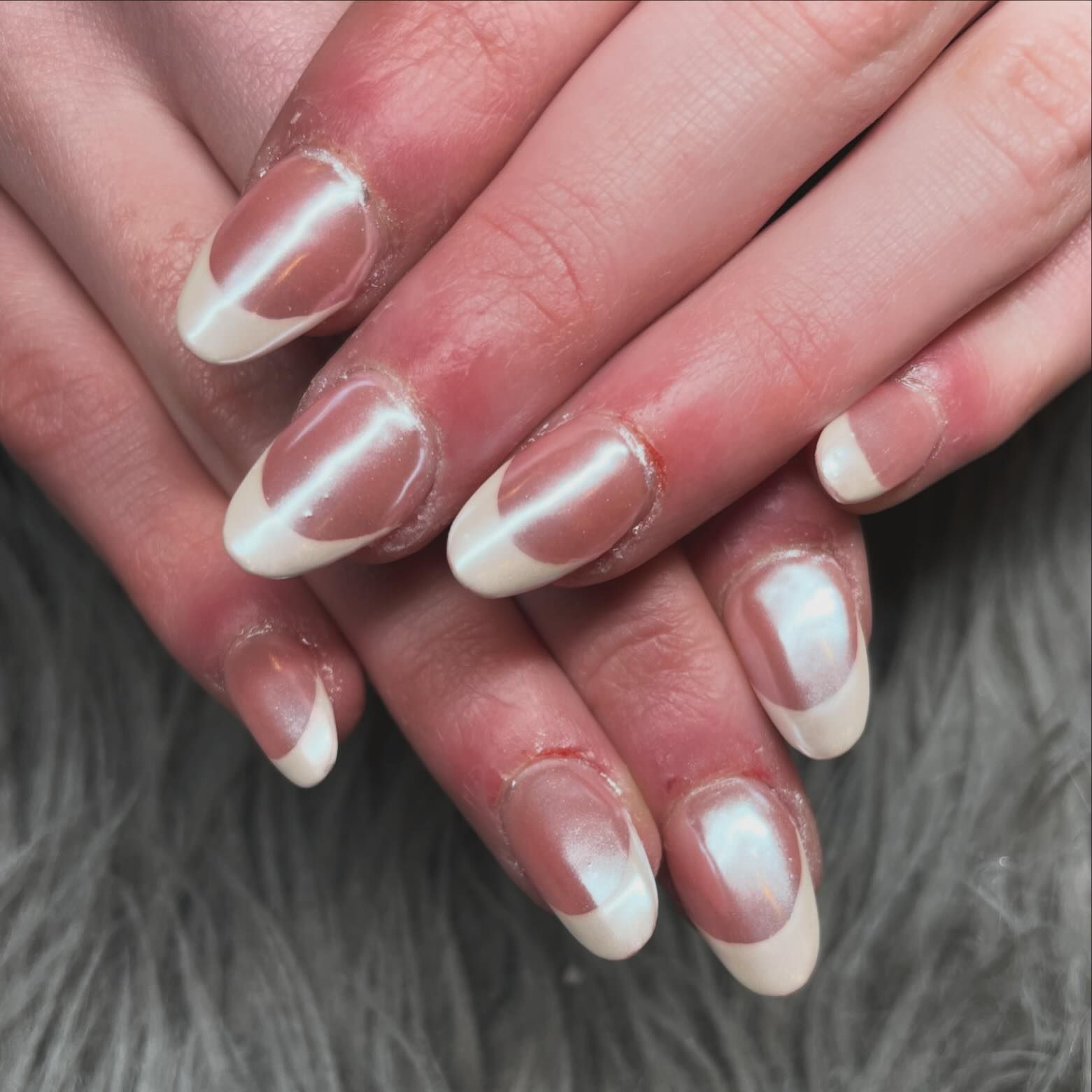 A close up of a woman 's nails with a french manicure