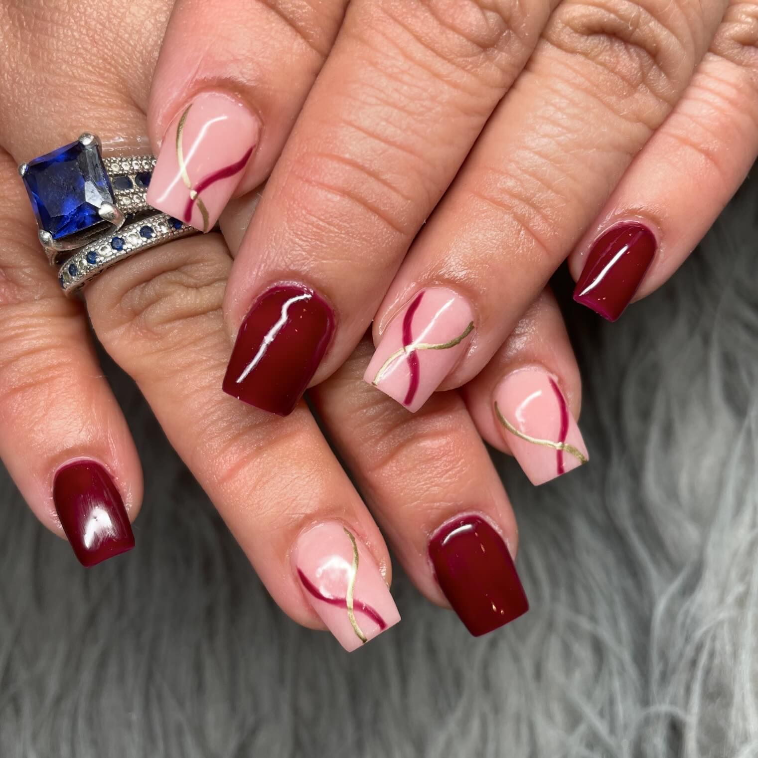 A close up of a woman 's nails with a ring on her finger
