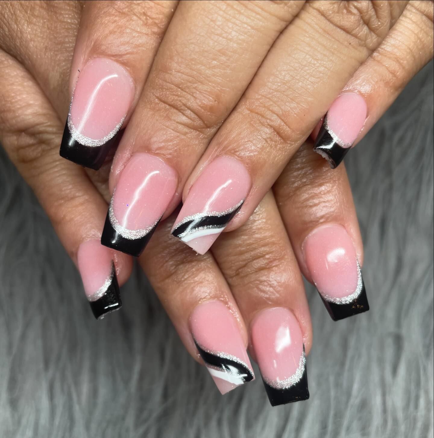 A close up of a woman 's nails with a black and white design