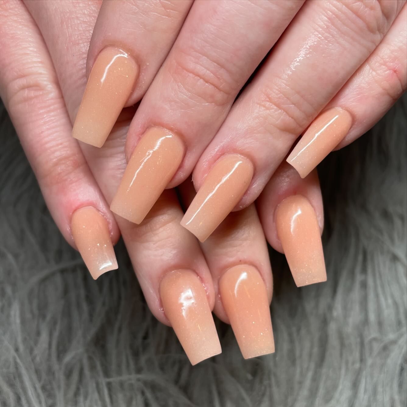 A close up of a woman 's nails with long acrylic nails