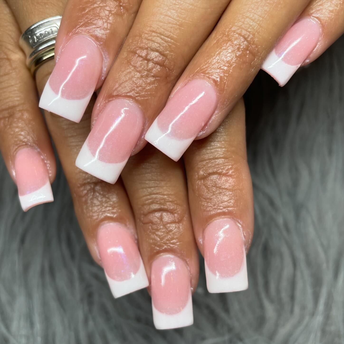 A close up of a woman 's nails with pink and white french manicure