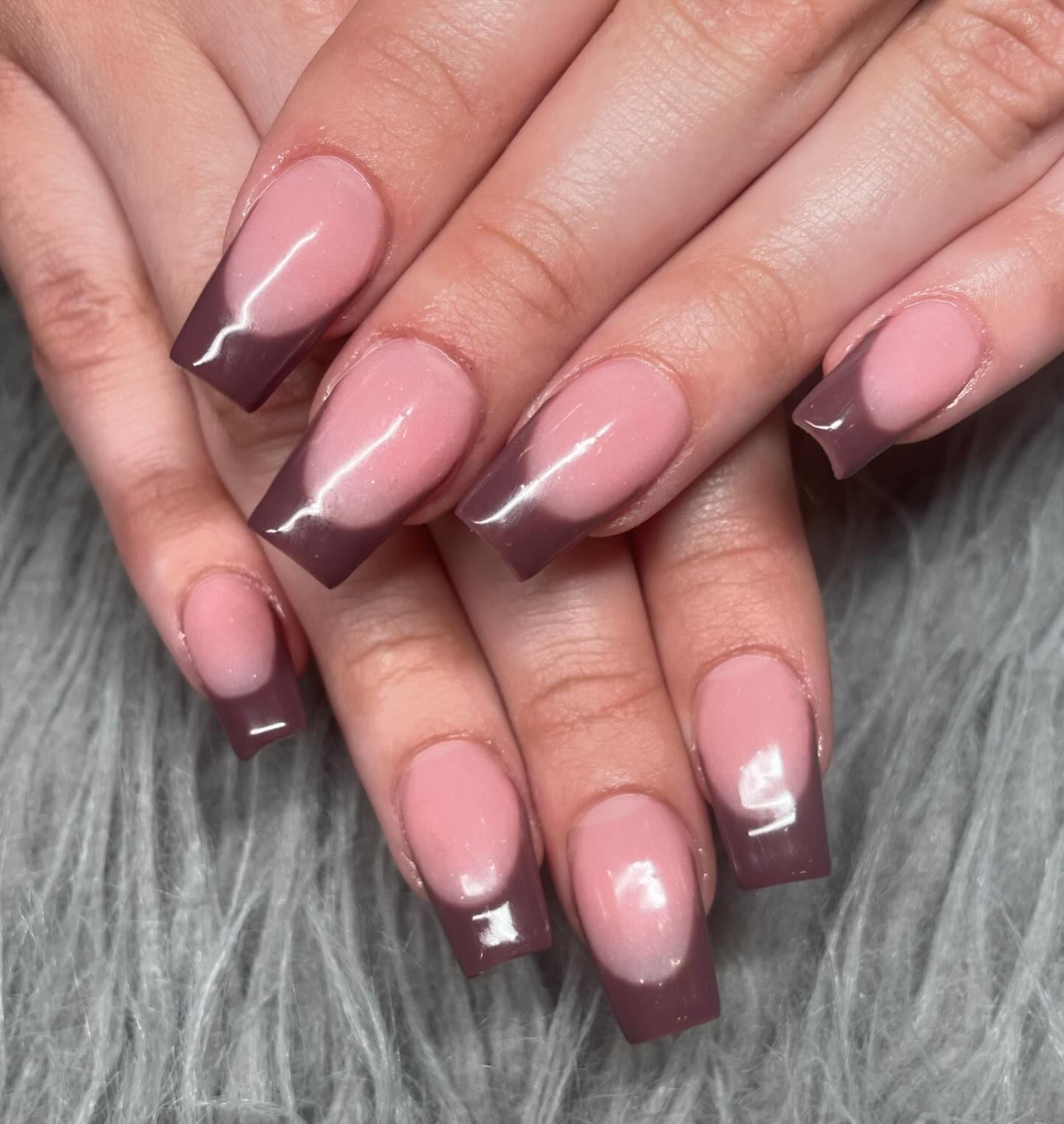A close up of a woman 's nails with a french manicure