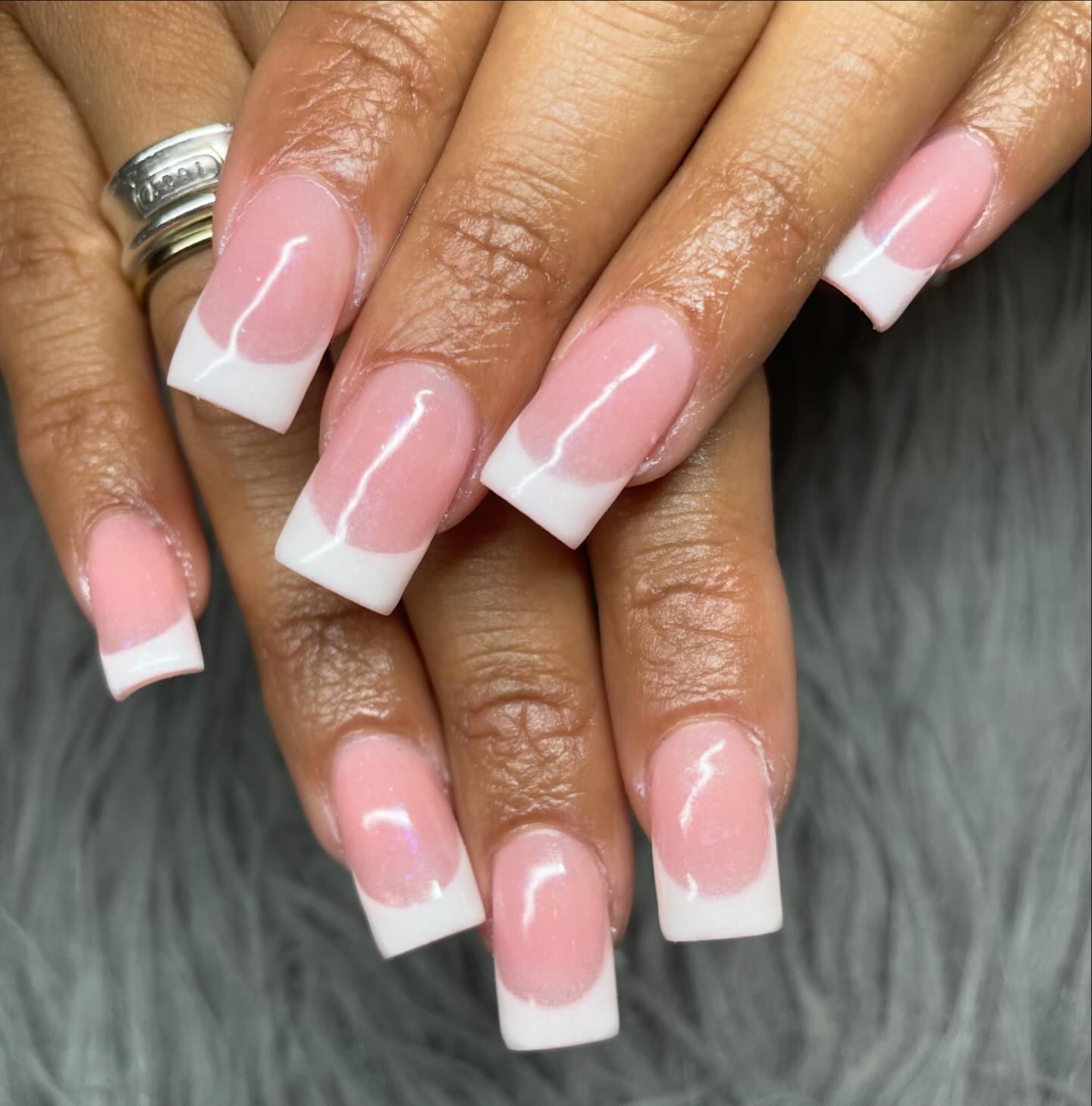 A close up of a woman 's nails with pink and white french manicure
