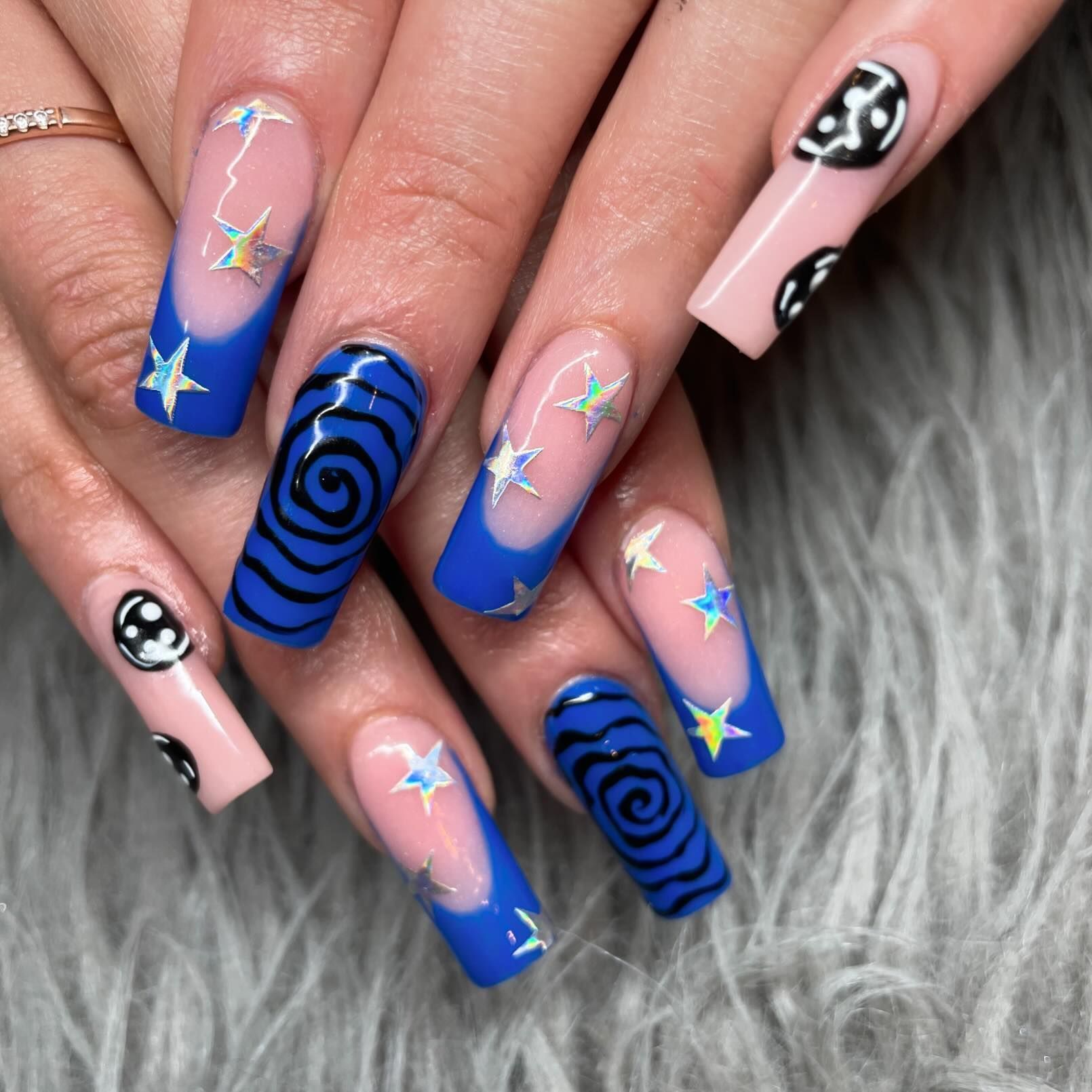 A close up of a woman 's nails with swirls and stars