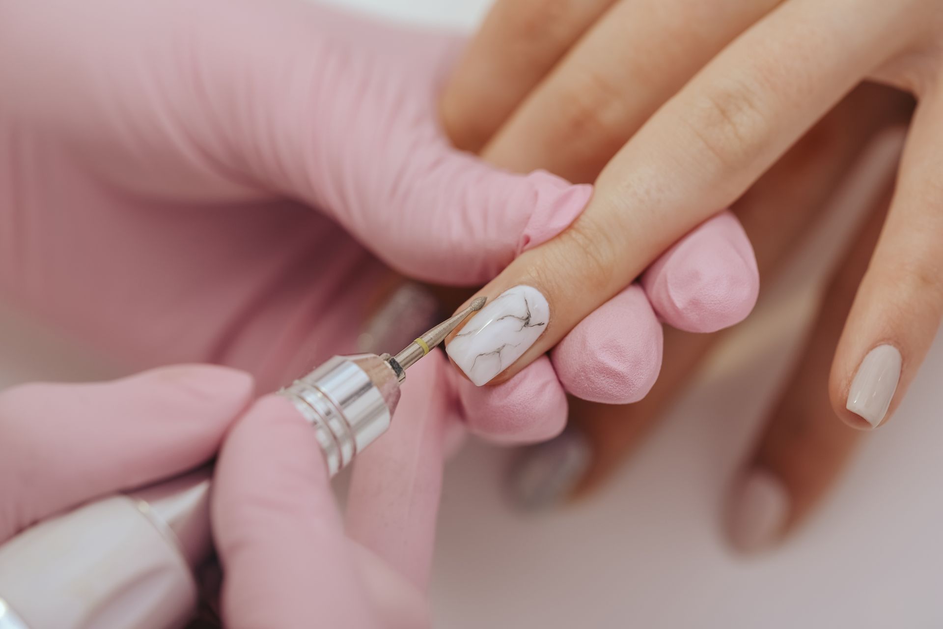 A woman is getting her nails done at a nail salon.