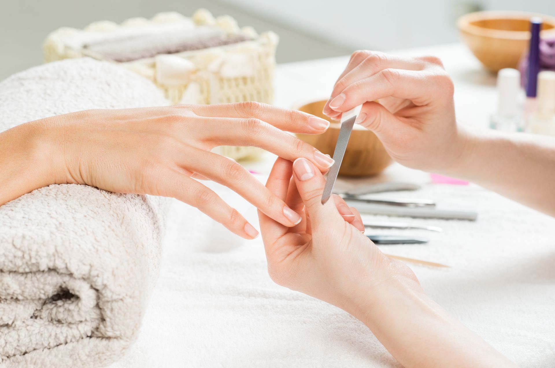 A woman is getting her nails done at a nail salon.