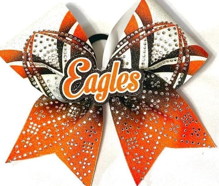 Cheerleader in red uniform performs a backbend on a green and red football field.