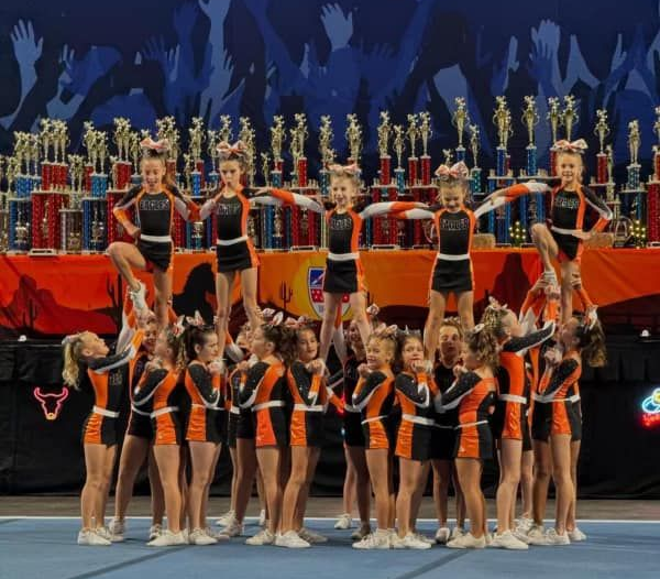 Red, white, and blue pom-poms held high by cheerleaders during a performance.