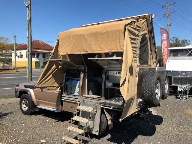 A Truck With A Tent On Top Of It Is Parked On The Side Of The Road — Perkins Caravans in Ballina, NSW