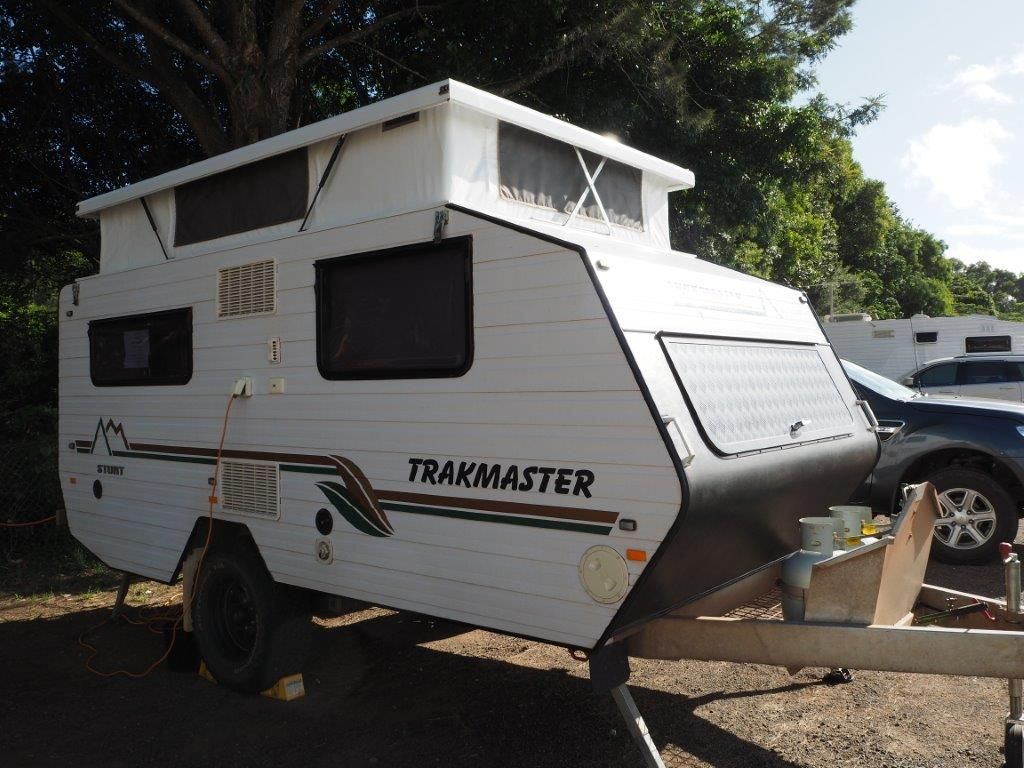 A White Trailer With The Word Trakmaster On It Is Parked In A Parking Lot — Perkins Caravans in Ballina, NSW