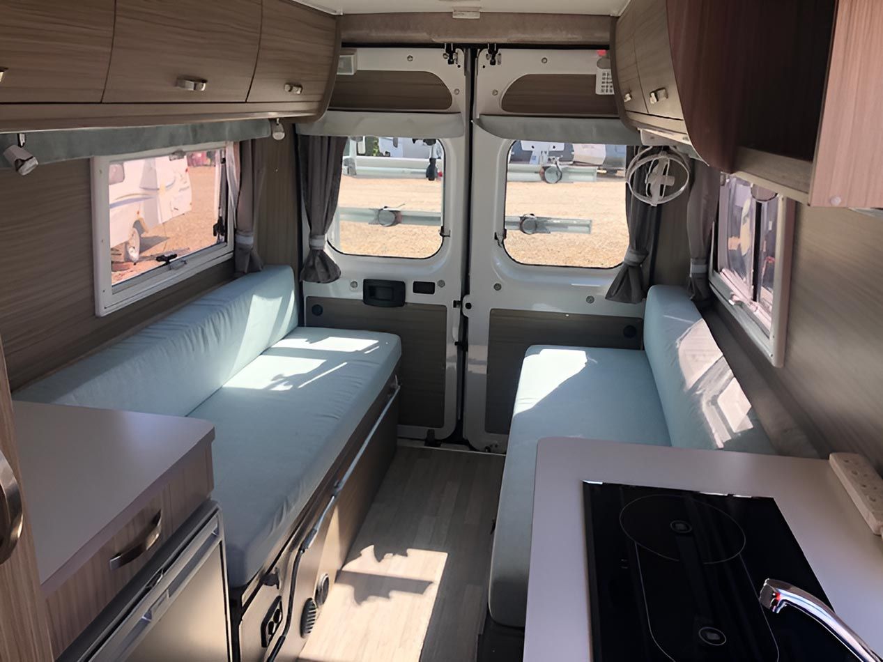 The Inside Of A Camper Van With A Couch And A Sink — Perkins Caravans in Lismore, NSW