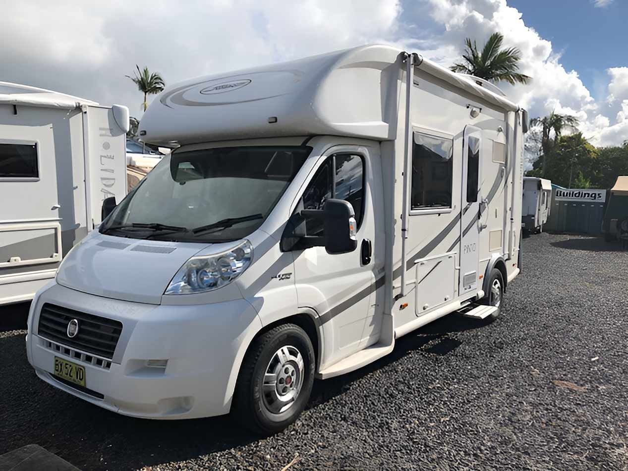 A White Motorhome Is Parked In A Gravel Lot — Perkins Caravans in Ballina, NSW