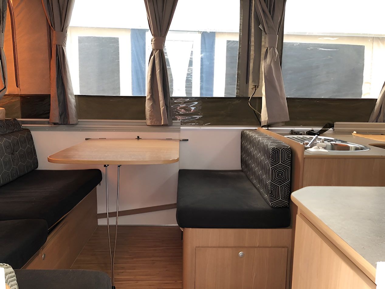 The Inside Of A Camper With A Table And Benches — Perkins Caravans in Grafton, NSW