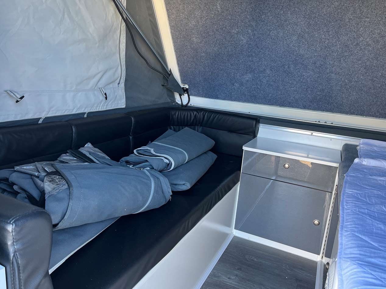 A Bed With A Blanket On It In A Camper — Perkins Caravans in Ballina, NSW