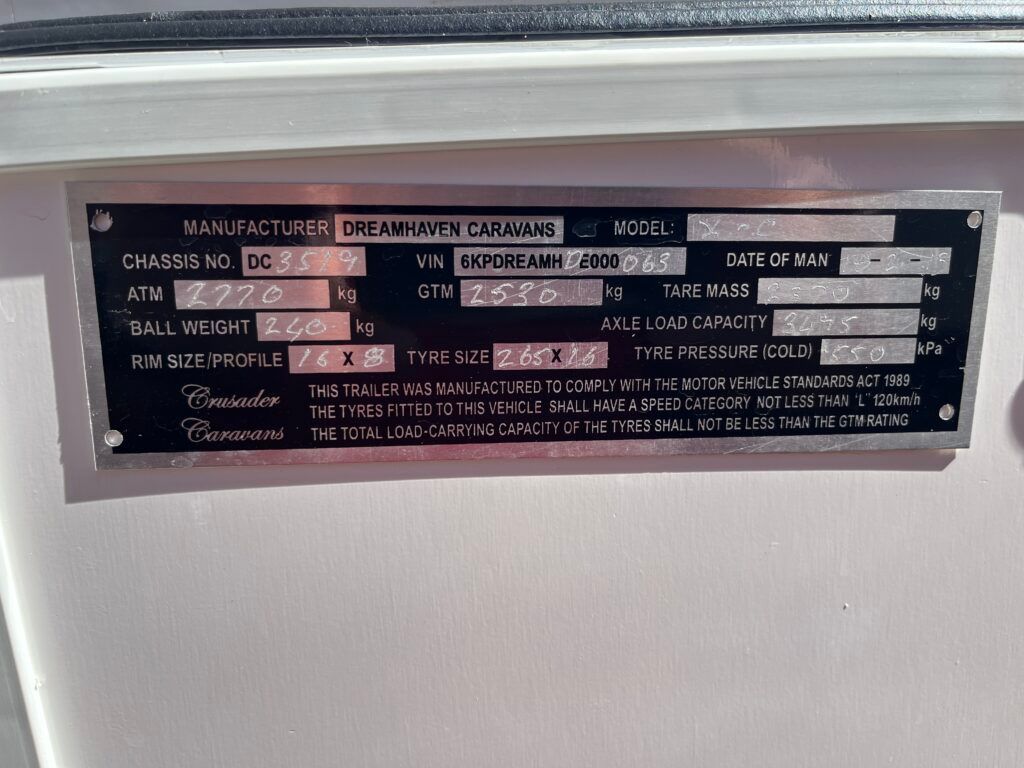 A White Wall With A Black Label That Says Manufacturing On It — Perkins Caravans in Ballina, NSW