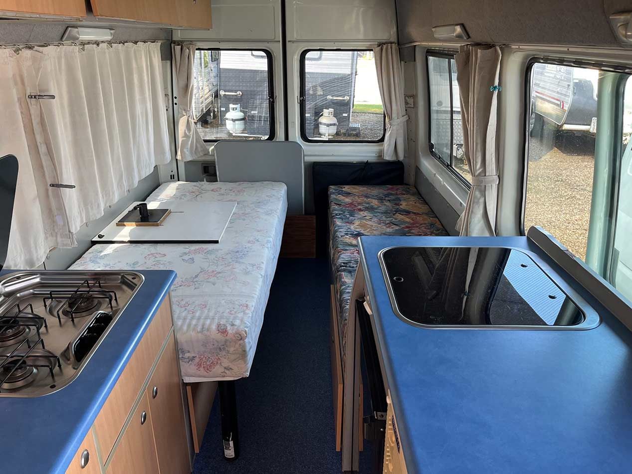 The Inside Of A Camper Van With A Stove And Sink — Perkins Caravans in Yamba, NSW