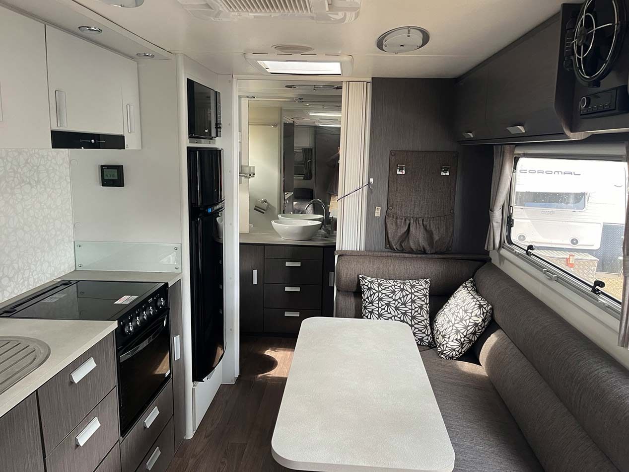A Living Room In A Camper With A Table And Couch — Perkins Caravans in Ballina, NSW