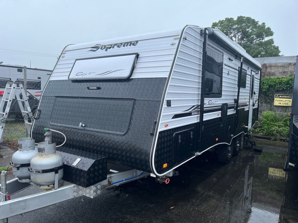 A Black And White Trailer Is Parked In A Parking Lot — Perkins Caravans in Ballina, NSW