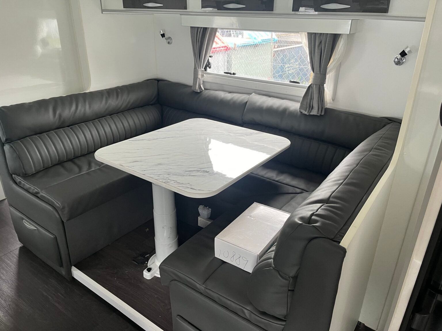 A Living Room With Black Leather Couches And A Table — Perkins Caravans in Ballina, NSW