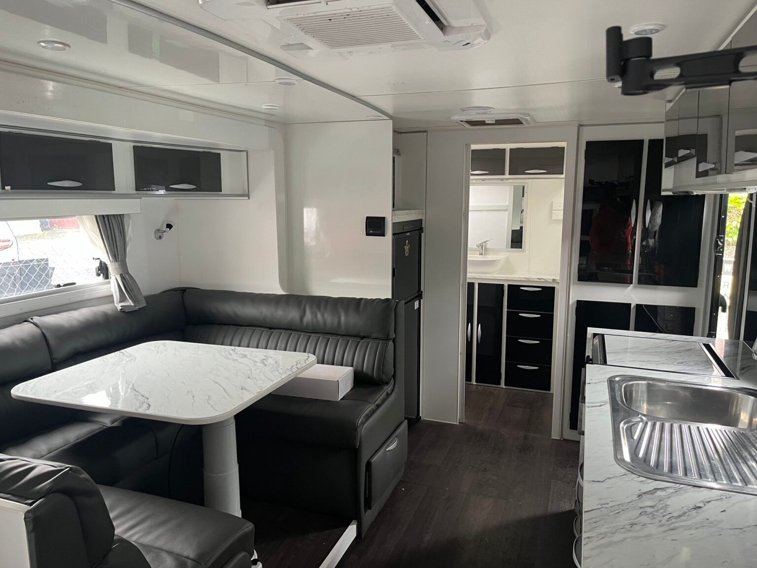 A Living Room In A Camper With A Table And Couch — Perkins Caravans in Ballina, NSW