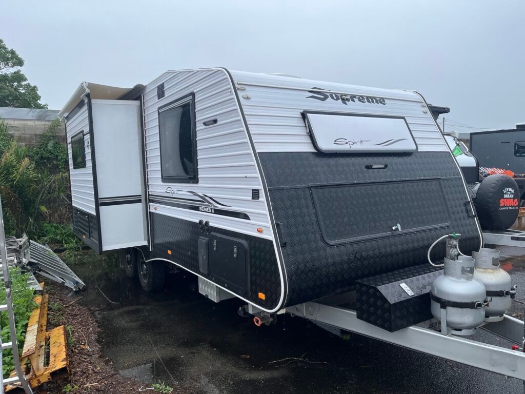 A White And Black Trailer Is Parked On The Side Of The Road — Perkins Caravans in Ballina, NSW