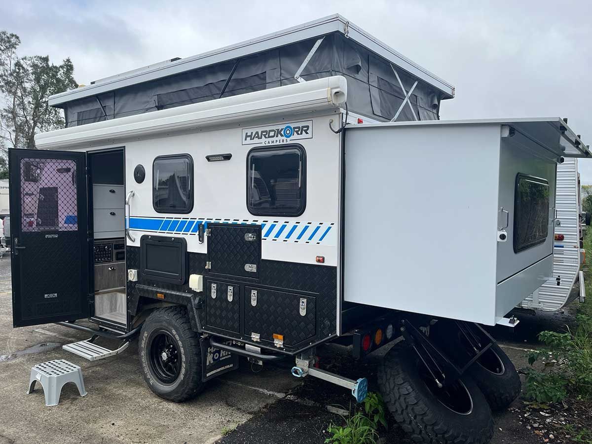 A White Caravan With The Doors Open Is Parked In A Parking Lot — Perkins Caravans in Ballina, NSW