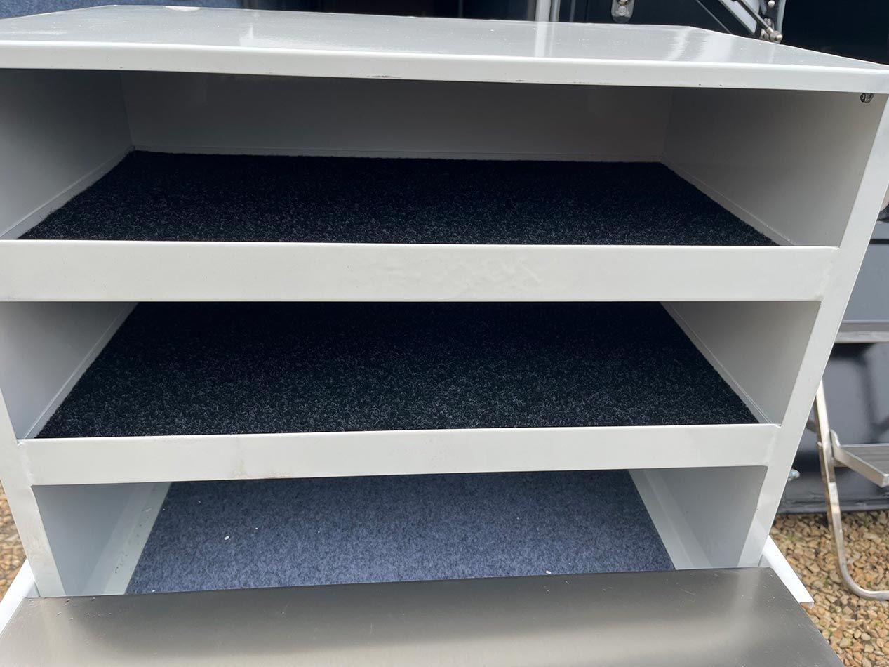 A White Shelf With Three Shelves And A Black Mat On The Bottom Shelf — Perkins Caravans in Ballina, NSW