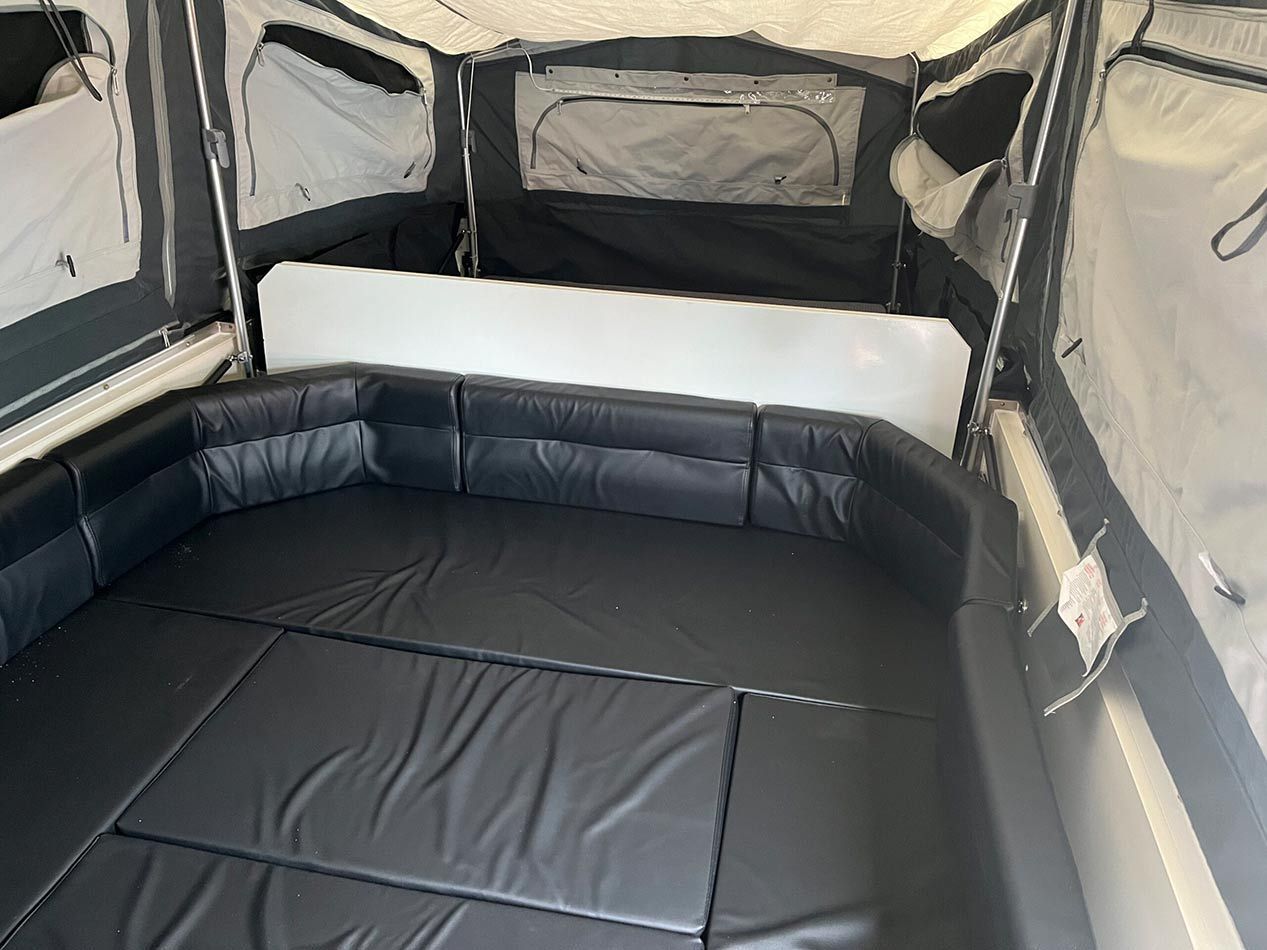The Inside Of A Camper With A Bed And A Window — Perkins Caravans in Ballina, NSW