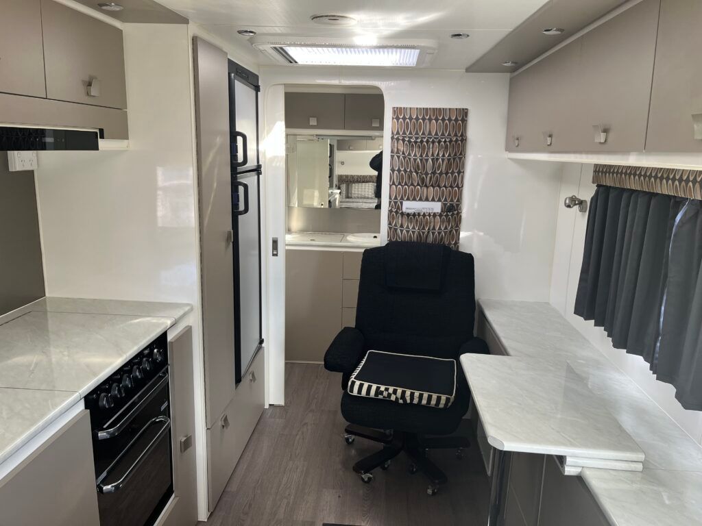 The Inside Of A Camper With A Chair And A Desk — Perkins Caravans in Ballina, NSW